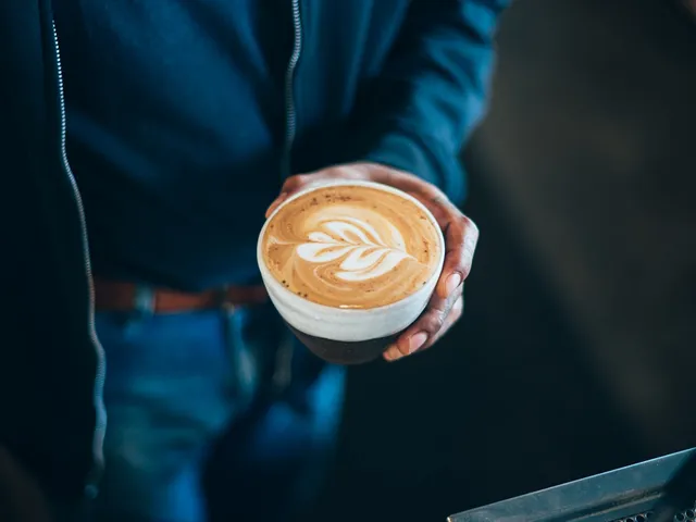 Un barista tend un latte fraîchement préparé